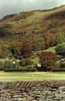sunlit hillside with dry stone wall