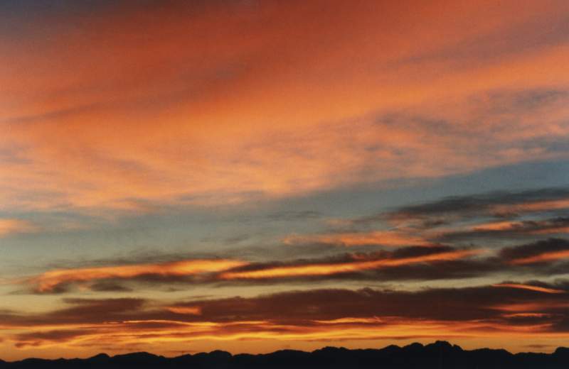 sunrise on layered cirrus above mountains