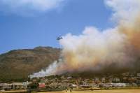 Twin-rotor Kamov helicopters water-bombing the fire above Muizenberg