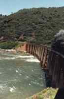 steam train crossing bridge over river