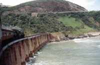 steam train crossing bridge over river